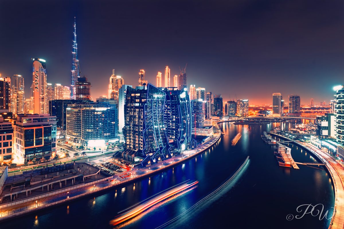 Dubai Water Canal skyline at night with boat light trails